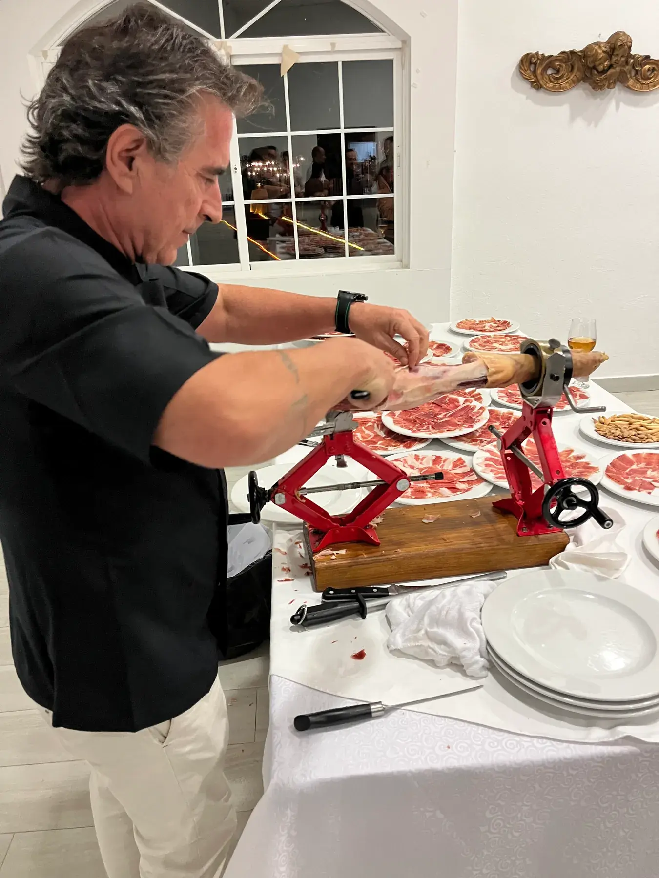 Sergio cortando lonchas de jamón con Carher94 durante el evento