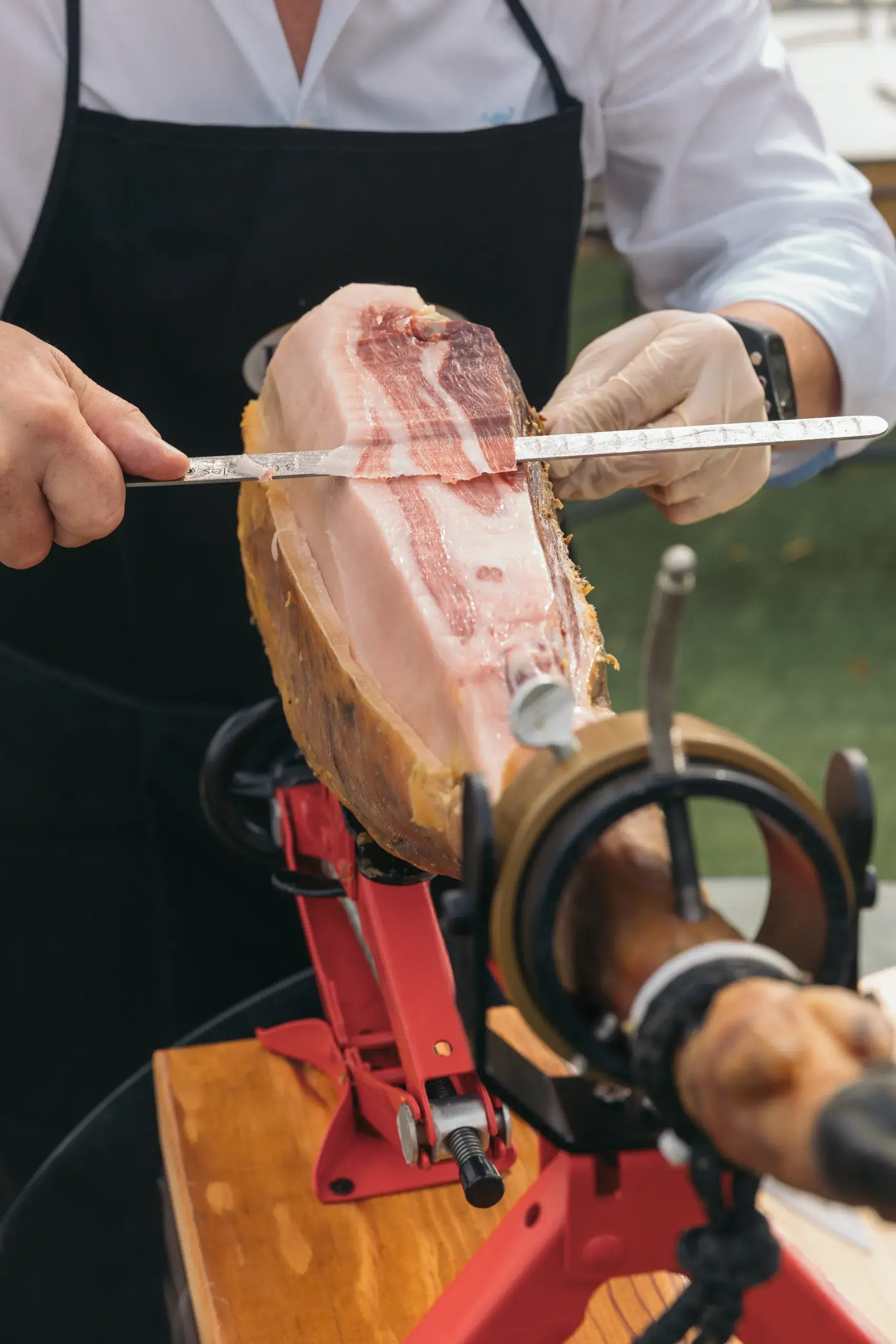 Corte de un jamón colocado en vertical sobre el jamonero